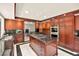 Spacious kitchen with dark wood cabinetry, stainless steel appliances, and a central island with gas cooktop at 226 Dalmatian Ln, Las Vegas, NV 89107