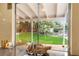 Kitchen window overlooks the beautiful backyard with green lawn, landscaped garden and white fence at 226 Dalmatian Ln, Las Vegas, NV 89107