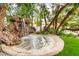 Beautiful backyard water feature with a rock waterfall and lush greenery, creating a peaceful oasis at 226 Dalmatian Ln, Las Vegas, NV 89107
