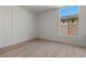 Minimalist bedroom with paneling, hardwood floors, and a large window offering exterior views at 2508 Faiss Dr, Las Vegas, NV 89134