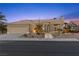Inviting single-story home boasts desert landscaping, exterior lighting, and a three-car garage at 2508 Faiss Dr, Las Vegas, NV 89134