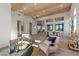 Open-concept living room with wood-beamed ceilings, white brick accent wall, and seamless flow to dining and kitchen areas at 2508 Faiss Dr, Las Vegas, NV 89134