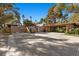 Beautiful exterior with a porte cochere, mature trees, and desert landscaping create inviting curb appeal at 2961 Augusta Dr, Las Vegas, NV 89109