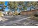 Spacious three-car garage with ample parking space, set amidst mature trees and desert landscaping at 2961 Augusta Dr, Las Vegas, NV 89109