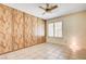 Bedroom featuring wood paneling, ceiling fan, shutters, and tile floors at 3063 Chapala Dr, Las Vegas, NV 89120