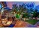 Cozy backyard featuring a unique hanging chair, outdoor seating, and beautiful landscaping at 326 Caneflower Ct, North Las Vegas, NV 89031