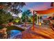 Lush backyard with a charming water fountain, well-manicured greenery, stone pavers, and an inviting patio set at 326 Caneflower Ct, North Las Vegas, NV 89031