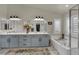 Bathroom with double sinks, soaking tub, and a large mirror at 326 Caneflower Ct, North Las Vegas, NV 89031