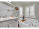 A relaxing bathroom with a soaking tub under shuttered windows at 326 Caneflower Ct, North Las Vegas, NV 89031