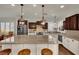 Spacious kitchen features white and dark wood cabinets, pendant lighting and granite countertops at 326 Caneflower Ct, North Las Vegas, NV 89031