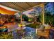 Covered patio with stylish outdoor seating, vibrant blue rug, and a view of the beautifully landscaped backyard at 326 Caneflower Ct, North Las Vegas, NV 89031