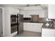 Modern kitchen with stainless steel appliances, granite countertops, and white cabinets at 3260 N Heritage Way, Las Vegas, NV 89121