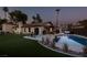 Dusk view of the backyard featuring a pool, patio, and manicured lawn, creating a serene and inviting outdoor space at 3708 Lorraine Ln, Las Vegas, NV 89120