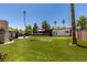 Expansive backyard featuring lush green turf, mature palm trees and potential for outdoor activities and relaxation at 3708 Lorraine Ln, Las Vegas, NV 89120