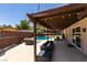 Spacious covered patio with comfortable seating, a grill, and a view of the sparkling pool beyond at 3708 Lorraine Ln, Las Vegas, NV 89120