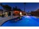 Backyard at dusk features a swimming pool illuminated by string lights with a covered patio and seating area at 3708 Lorraine Ln, Las Vegas, NV 89120