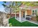 Backyard view featuring a covered patio with BBQ grill and manicured lawn at 4036 W Bird Man Ln, North Las Vegas, NV 89084