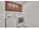 Laundry room features washer and dryer with storage cabinets above at 4036 W Bird Man Ln, North Las Vegas, NV 89084