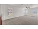 Open loft with neutral carpeting, fan, and bright natural light streaming through shuttered windows at 4036 W Bird Man Ln, North Las Vegas, NV 89084