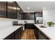 Modern kitchen boasts dark cabinetry, stainless steel appliances, and a quartz countertop island with bar seating at 4348 Bayley Skye Ave, Las Vegas, NV 89141