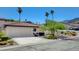 Single-story home featuring a spacious driveway leading to a two-car garage with desert landscaping and palm trees at 439 Columbia Ct, Boulder City, NV 89005