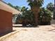 Expansive backyard features mature palm trees alongside a red brick home and chainlink fence at 4950 Burnham Ave, Las Vegas, NV 89119