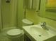 A compact bathroom features a shower, toilet, sink, and storage, with a tiled floor and yellow walls at 4950 Burnham Ave, Las Vegas, NV 89119