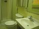 A compact bathroom features a shower, toilet, sink, and storage, with a tiled floor and yellow walls at 4950 Burnham Ave, Las Vegas, NV 89119