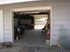 Spacious garage with high ceilings leading to second garage with door open to backyard at 4950 Burnham Ave, Las Vegas, NV 89119