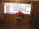 A cozy living room features wood paneling, large windows with curtains, and a small table with flowers at 4950 Burnham Ave, Las Vegas, NV 89119