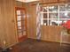 A cozy living room features wood paneling, large windows, an exterior door, and a small table with flowers at 4950 Burnham Ave, Las Vegas, NV 89119