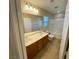 This primary bathroom boasts a double sink vanity, a tub, and tiled flooring at 5361 Candlespice Way, Las Vegas, NV 89135