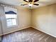 This bedroom features a ceiling fan and a window dressed with blinds and a decorative valance at 5361 Candlespice Way, Las Vegas, NV 89135