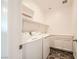 Bright laundry room featuring a washer, dryer, upper shelving, and countertop space for folding at 5606 Verde Valley Ct, North Las Vegas, NV 89081