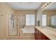 Bright bathroom with walk in shower, large soaking tub, double sink vanity, and large framed mirror at 5916 Sorto Lago St, North Las Vegas, NV 89081