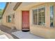 Inviting home exterior with a red front door flanked by windows, desert landscaping and a well-kept facade at 5916 Sorto Lago St, North Las Vegas, NV 89081
