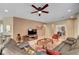 Comfortable living room with a ceiling fan, large sofa, and an entertainment center underneath the mounted television at 5916 Sorto Lago St, North Las Vegas, NV 89081