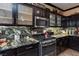 Kitchen featuring granite countertops, black cabinets, stainless steel appliances, and tile flooring at 6007 Turtle River Ave, Las Vegas, NV 89156