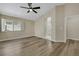 Spacious bedroom features wood-look floors, a ceiling fan, and an en suite bathroom at 6035 Shadow Oak Dr, North Las Vegas, NV 89031