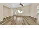 Bright living room with vaulted ceiling, wood-look floors, and a ceiling fan at 6035 Shadow Oak Dr, North Las Vegas, NV 89031