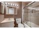 Bathroom featuring a tub with glass door, single sink vanity, and bulb lighting at 6213 Fairwood Ave, Las Vegas, NV 89107