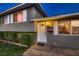 Welcoming front entrance with a classic door, neatly trimmed bushes, and an inviting glow at 6213 Fairwood Ave, Las Vegas, NV 89107