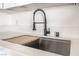 Close up of the kitchen sink featuring stainless steel sink, faucet, and wood cutting board at 6444 Bannock Way, Las Vegas, NV 89107