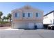 Two-story tan home featuring a three-car garage and tidy landscaping at 6459 Rusticated Stone Ave # 103, Henderson, NV 89011