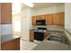 Functional kitchen featuring tile floors, wood cabinets, and modern appliances at 6459 Rusticated Stone Ave # 103, Henderson, NV 89011