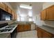Well-lit kitchen featuring Formica countertops, black appliances, and oak cabinets at 6459 Rusticated Stone Ave # 103, Henderson, NV 89011
