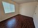 Bedroom with wood-look floor, window, door and white walls at 6824 Briarwood Bend Ave, Las Vegas, NV 89130