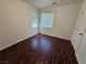 Bedroom featuring a window, door, wood-look floor and white walls at 6824 Briarwood Bend Ave, Las Vegas, NV 89130