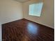 Neutral bedroom showcasing wood-look floors and a window at 6824 Briarwood Bend Ave, Las Vegas, NV 89130