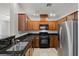 This kitchen features wooden cabinetry, stainless steel appliances, and granite countertops at 6868 Sky Pointe Dr # 2035, Las Vegas, NV 89131
